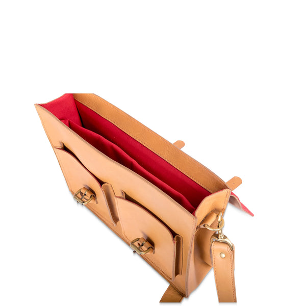 Tan leather handbag with red interior lining on a white background