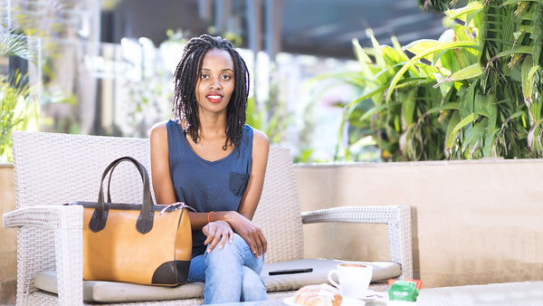 Woman sitting on a patio with a leather handbag and coffee cup