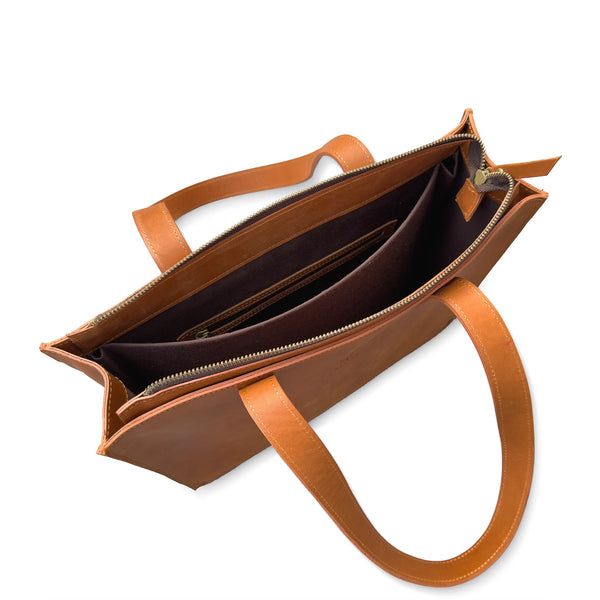 Brown leather handbag with open top on a white background