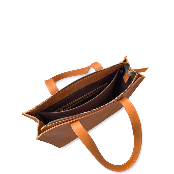 Brown leather handbag with open front pocket on a white background