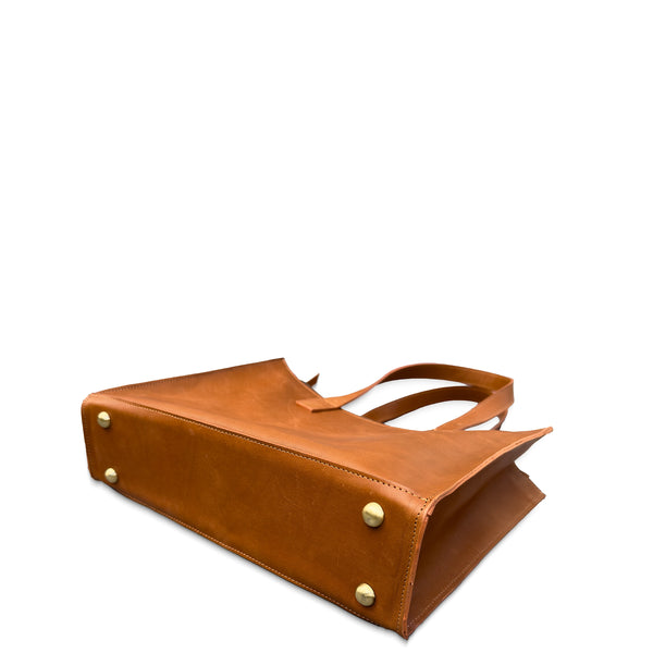 Brown leather handbag with gold studs on a white background