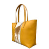 Tan tote bag with cow print pattern on a white background