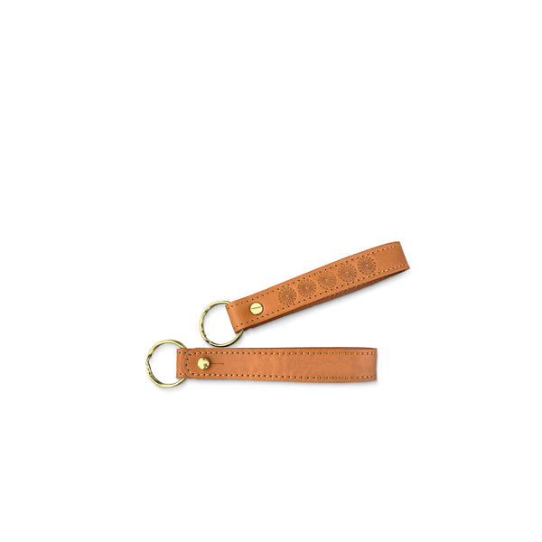 Brown leather keychain with gold hardware on a white background