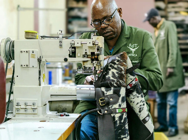 Man working on a sewing machine with a patterned fabric in a workshop setting.