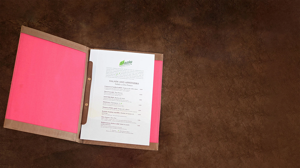leather menu with pink cover and white pages on a brown surface
