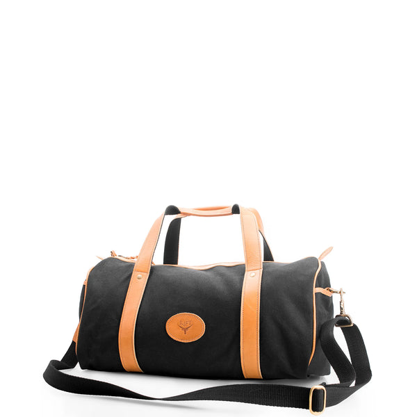 Black duffel bag with brown leather straps on a white background