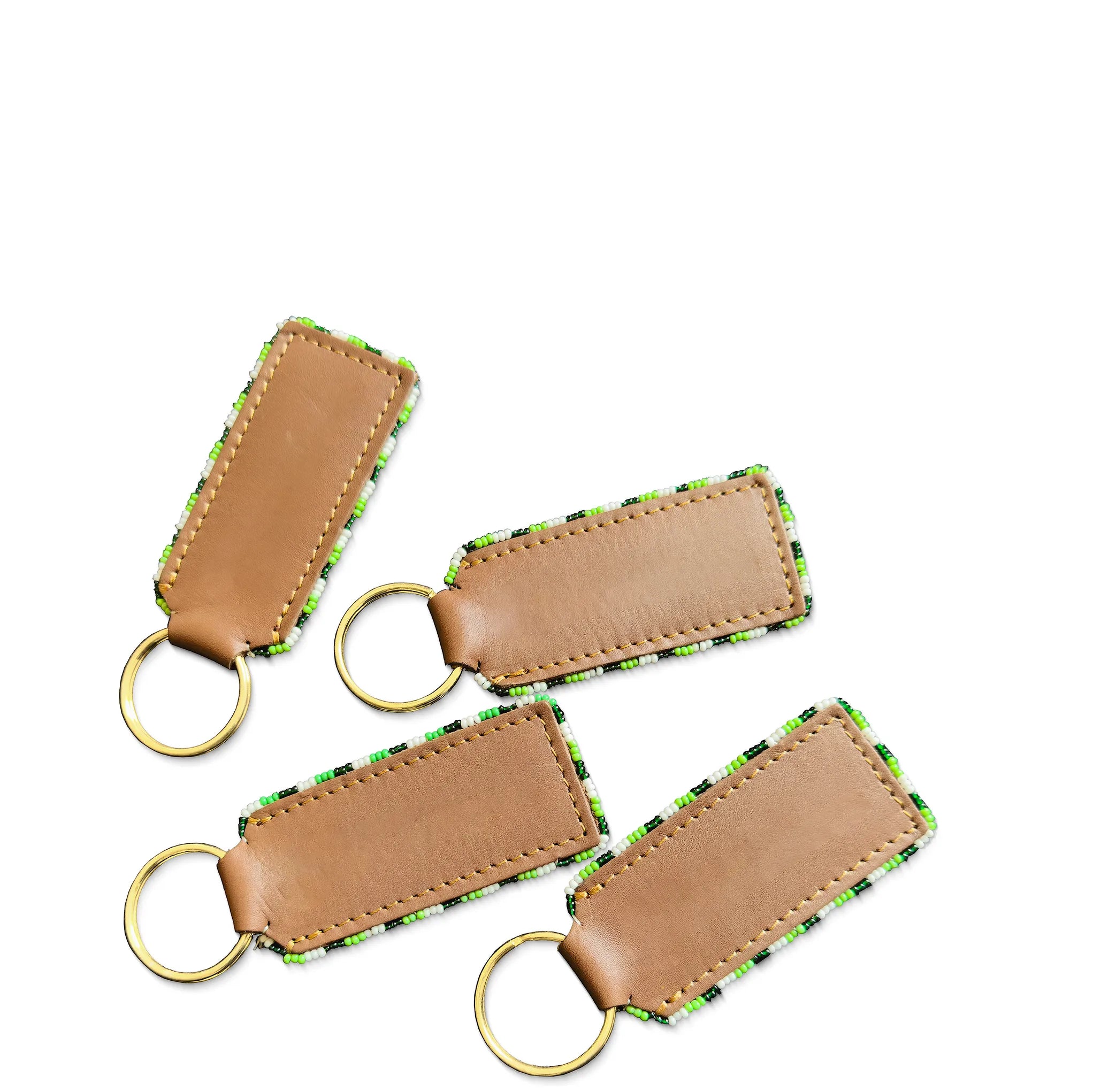 Four brown leather keychains with green stitching on a white background