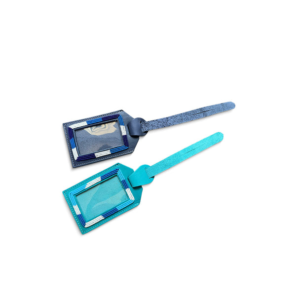 Two blue leather luggage tags on a white background