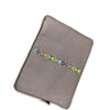 grey leather laptop sleeve with colorful geometric pattern on a white background