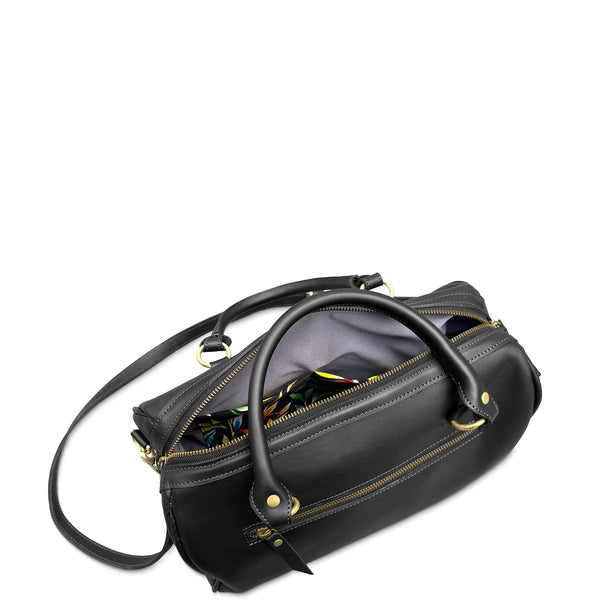 Black handbag with gold zippers on a white background