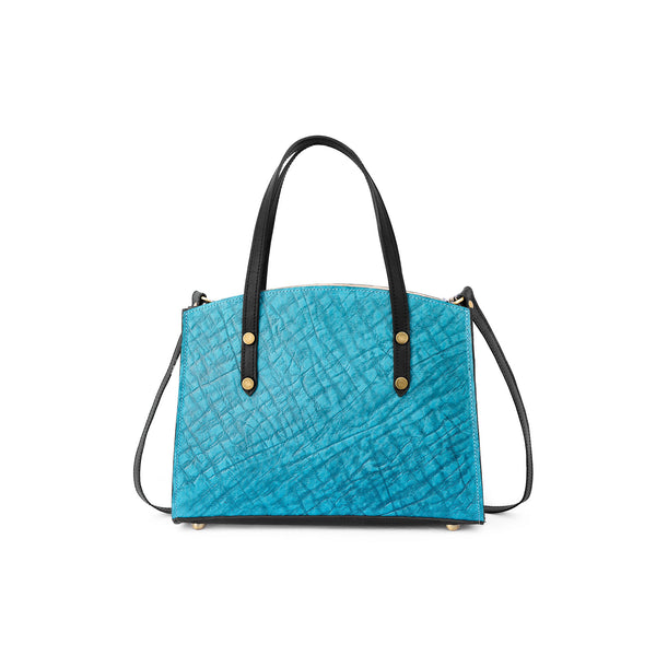 Blue textured leather handbag with black straps on a white background