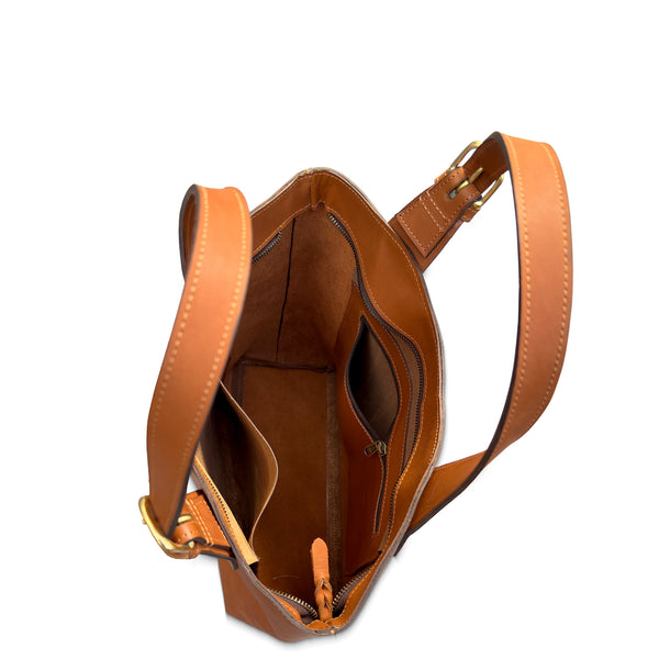 Brown leather handbag with a shoulder strap on a white background