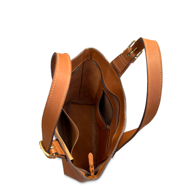 Brown leather handbag with a strap on a white background