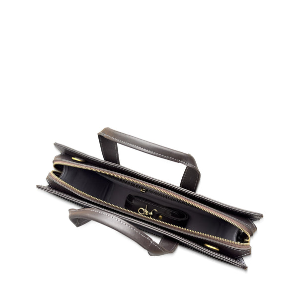 Brown leather handbag with gold zipper on a white background