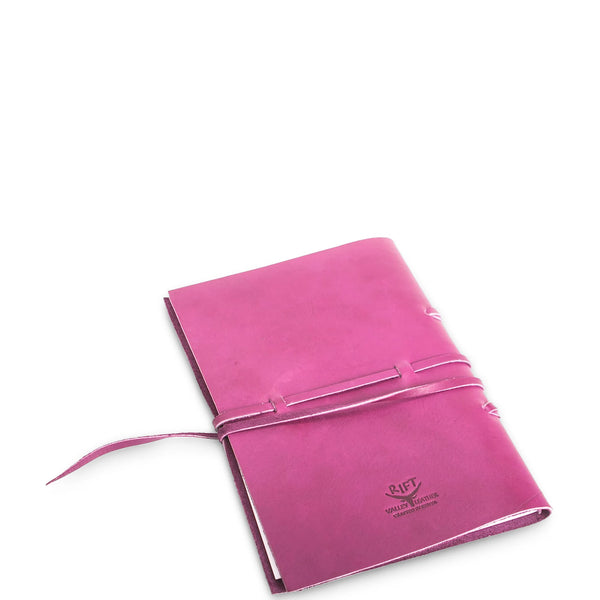 Pink leather-bound notebook with a strap on a white background