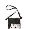 Black leather crossbody bag with cow print panel on a white background
