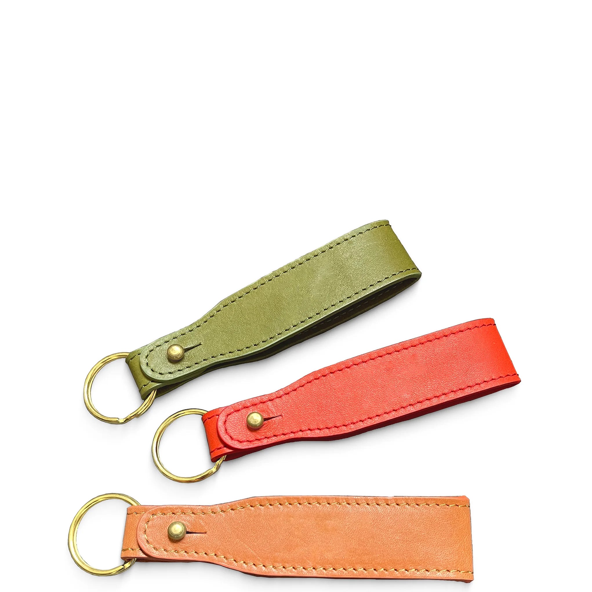 Three leather keychains in green, red, and orange on a white background