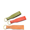 Three leather keychains in green, red, and orange on a white background