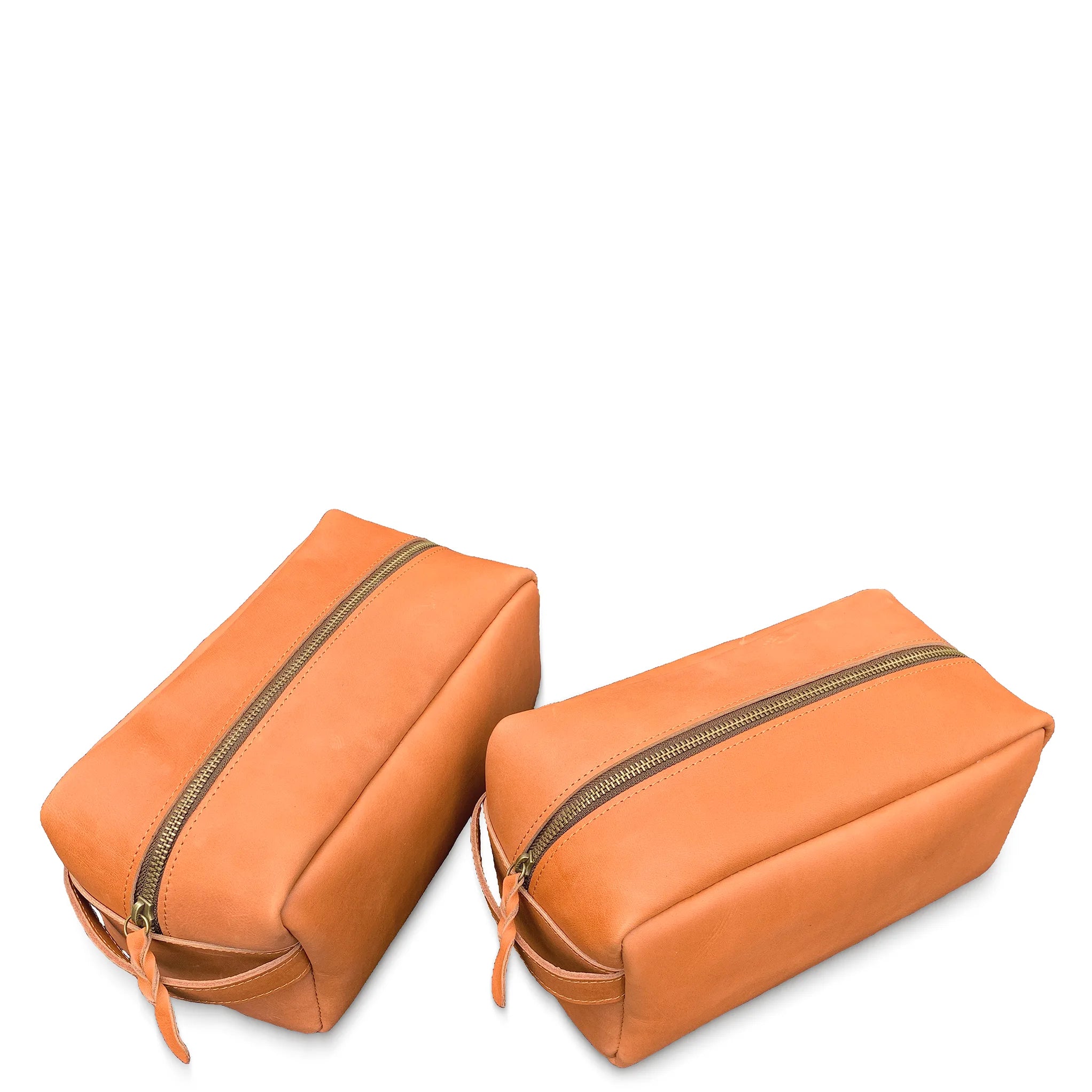 Two orange toiletry bags with zippers on a white background