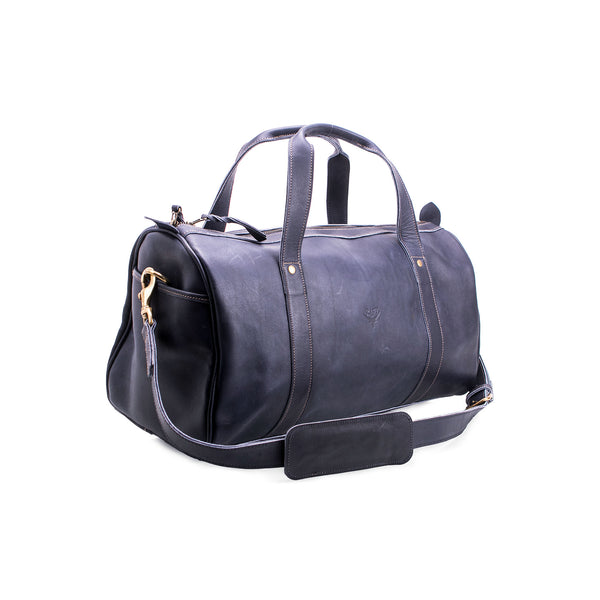 Black leather duffel bag with gold zipper pull on a white background