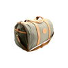 Green duffel bag with brown leather accents on a white background