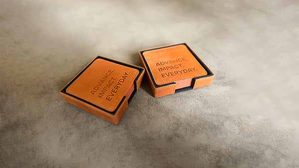 Two orange boxes with 'Advance Impact Everyday' text on a gray surface