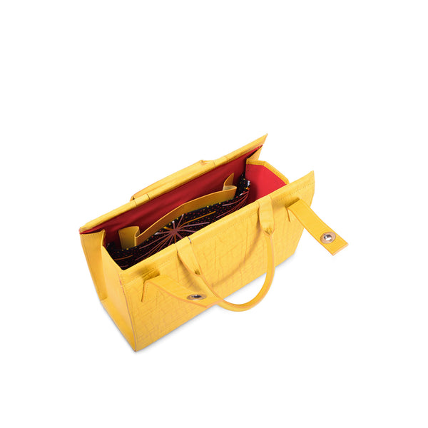 Yellow leather handbag with red interior on a white background