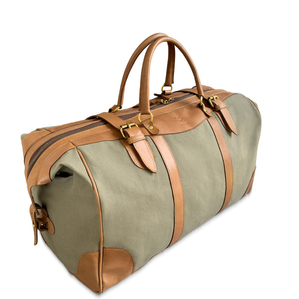 Green duffel bag with brown leather straps and handles on a white background