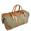 Green duffel bag with brown leather straps and handles on a white background