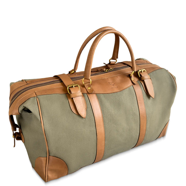 Green duffel bag with brown leather straps and handles on a white background
