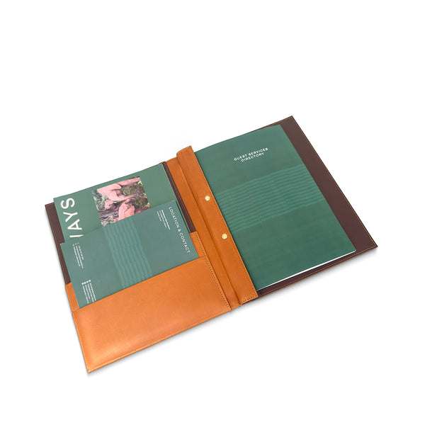 open leather room folder with green interior and brown leather cover on a white background