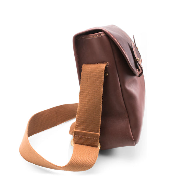 Brown leather bag with a matching strap on a white background
