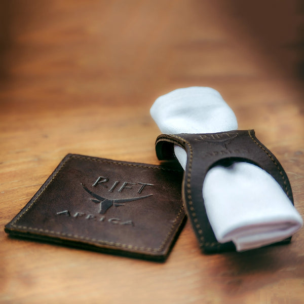 Brown leather coaster and napkin holder  on a wooden surface, featuring 'RIFT AFRICA' branding.