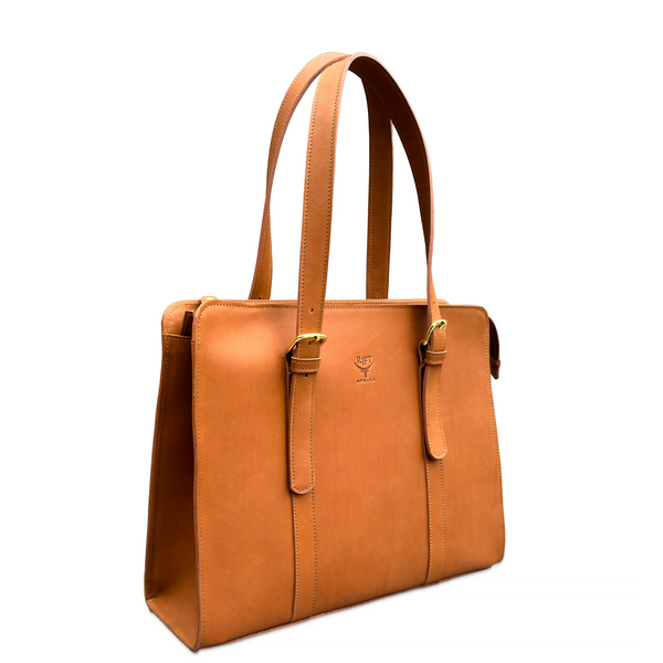 A tan leather tote bag with double shoulder straps, gold-tone buckle details, and a small embossed logo on the front, shown against a plain white background.