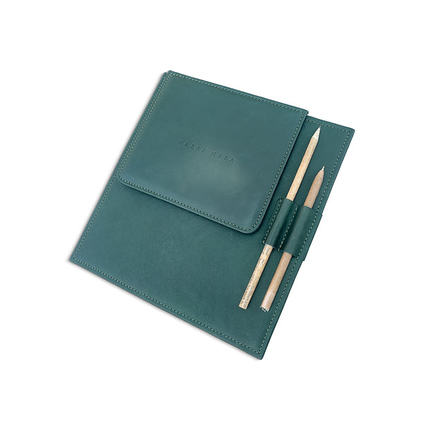 Teal leather note pad with two pens on a white background