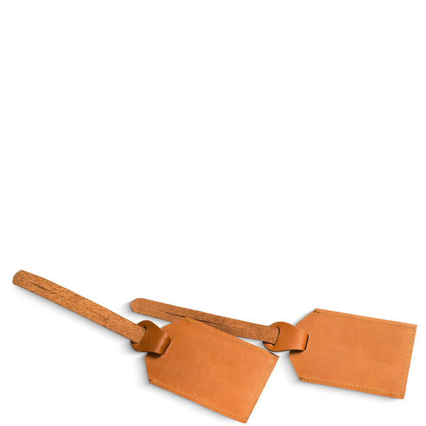 Two tan leather luggage tags on a white background