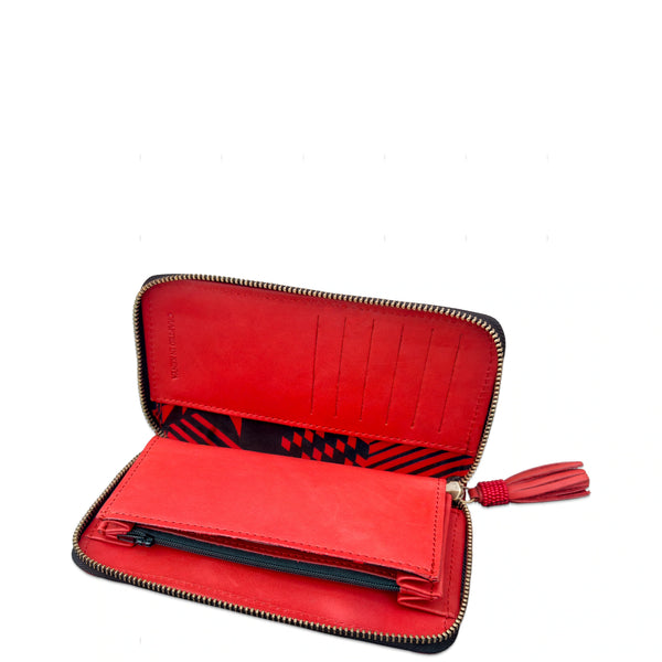 An open red zip-around wallet with multiple card slots, a patterned interior lining, and a red tassel zipper pull, shown on a plain white background.