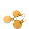 Three tan leather keychains on a white background