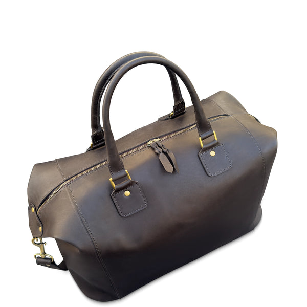 Brown leather duffel bag with gold hardware on a white background