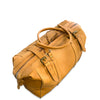 A tan leather duffel bag with dual top handles, buckle straps, and a zippered end, photographed on a clean white background.