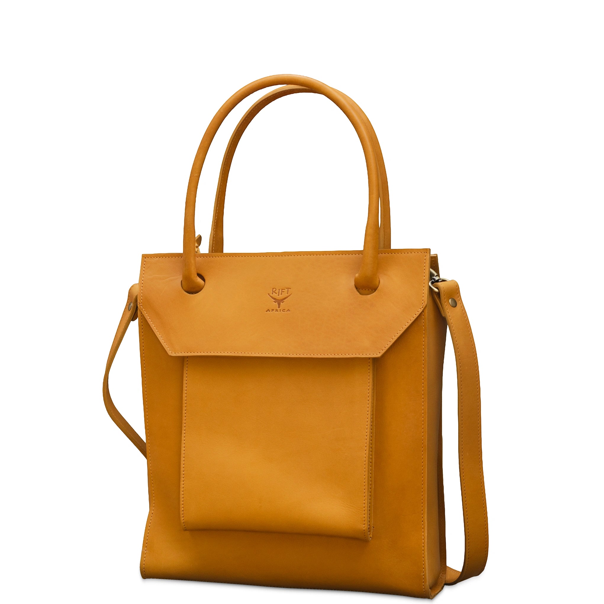 A mustard yellow leather tote bag with a front flap pocket, dual top handles, and a detachable shoulder strap, shown on a plain white background.