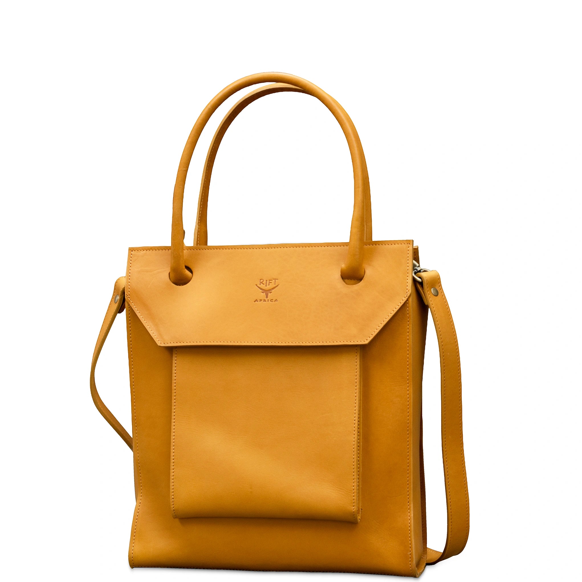 A tan leather tote bag with a front flap pocket, dual top handles, and a detachable shoulder strap, shown on a plain white background.