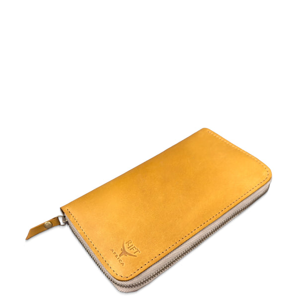 A tan leather zip-around wallet with a cream-colored zipper track and a small debossed logo on the front, shown on a plain white background.
