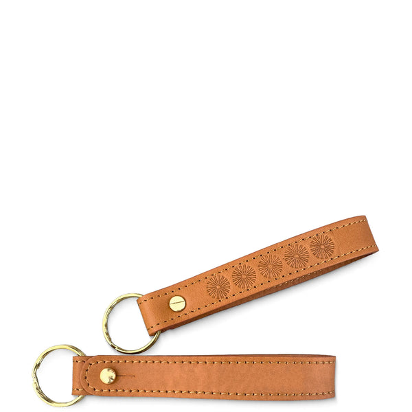 Brown leather keychain with embossed design on a white background