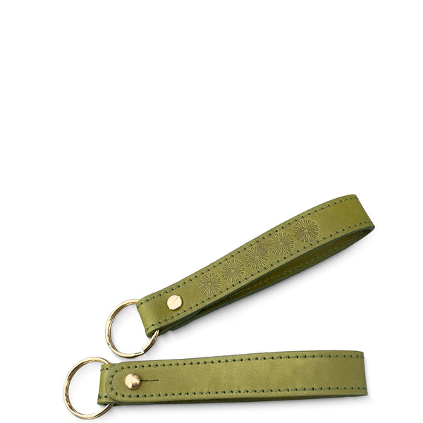 Green leather key fob with embossed design on a white background
