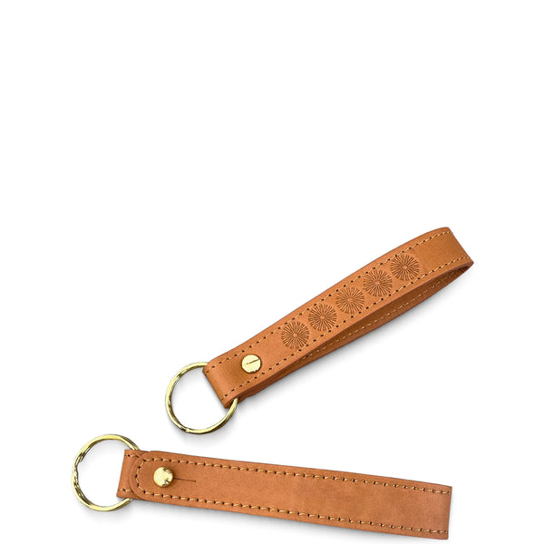 Brown leather keychain with embossed design on a white background