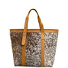 Tote bag with cowhide pattern and tan leather straps on a white background
