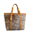Tote bag with cowhide pattern and tan leather straps on a white background